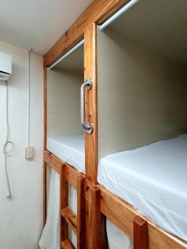 um par de beliches num pequeno quarto em Mabuhay Dauin Dorm Hostel em Dauin