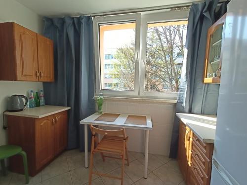 a small kitchen with a table and a window at Lemuria Jawor pokoje in Jawor