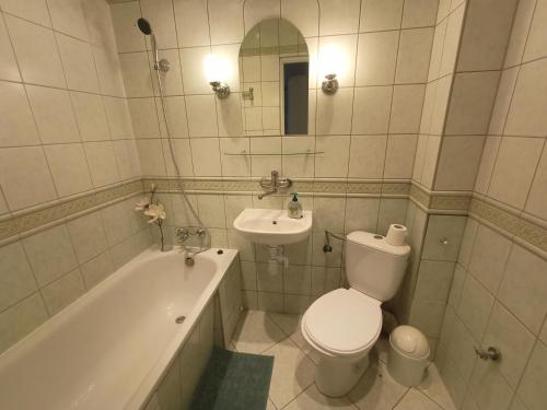 a white bathroom with a toilet and a sink at Lemuria Jawor pokoje in Jawor