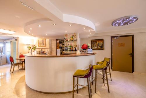 um bar numa sala com bancos em Hôtel Les Trois Roses, Meylan Grenoble The Originals Boutique em Meylan