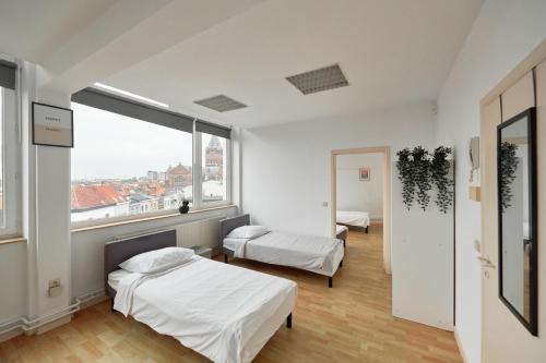 ein Schlafzimmer mit zwei Betten und einem großen Fenster in der Unterkunft BoLofts in Antwerpen