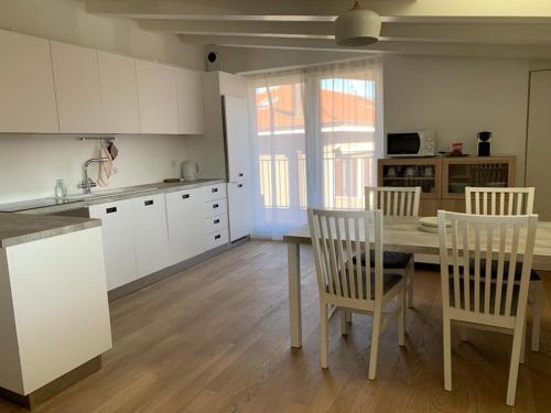 a kitchen with a table and chairs in a room at cairoli7novate-mansarda in Novate Milanese