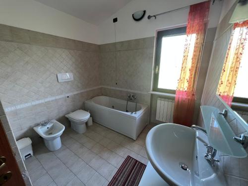 y baño con bañera, aseo y lavamanos. en Casa Meraviglia, en Montesilvano