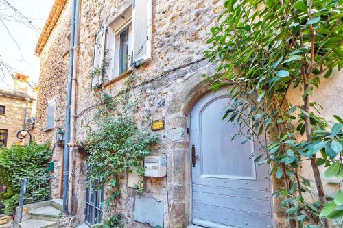 - un bâtiment en pierre avec une porte bleue dans l'établissement TOWNHOUSE MOUGINS in the old village, fantastic view, sea and mountains, à Mougins