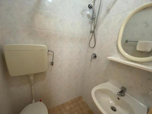 a bathroom with a toilet and a sink and a mirror at Hotel Nanni Garnì in Rimini