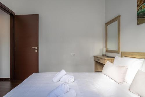 a white bed with white pillows and a mirror at Villa Casa del mar in Lygaria