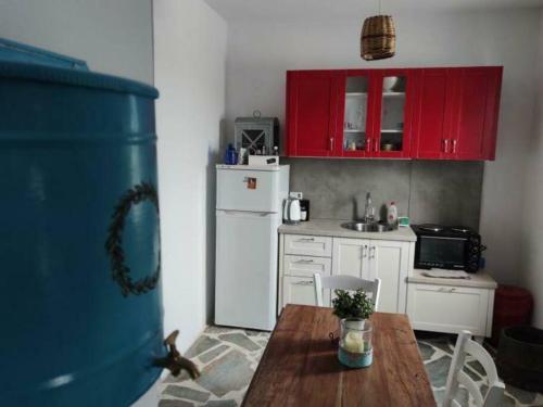a kitchen with a wooden table and a white refrigerator at Anna's Cottage Home in Galini