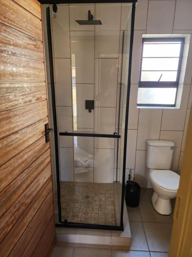 a shower in a bathroom with a toilet at Lloyds - 6 in Ermelo