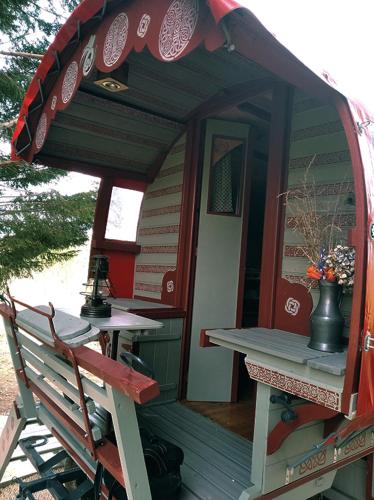 une petite maison avec une table et un banc dans l'établissement Roulotte irlandaise Polly, à Saint-Vincent-en-Bresse