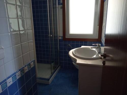 a blue tiled bathroom with a sink and a shower at una terraza al atlántico in Nigrán