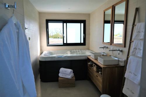 a bathroom with a tub and a sink and a mirror at Suites by Aix Keys avec jacuzzi privatif 5 min des plages Fouras in Saint-Laurent-de-la-Prée