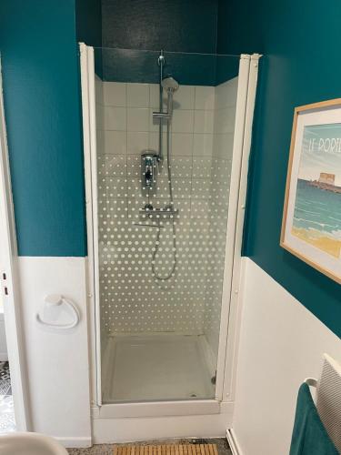 um chuveiro numa casa de banho com uma parede azul em Grand’Heurt 50m de la plage em Le Portel