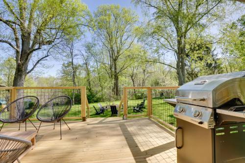 a patio with a grill and chairs on a deck at Mid-Century Modern Fayetteville Home Close to Town in Fayetteville