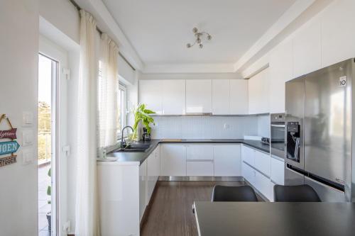 a kitchen with white cabinets and a table with chairs at Villa Casa del mar in Lygaria