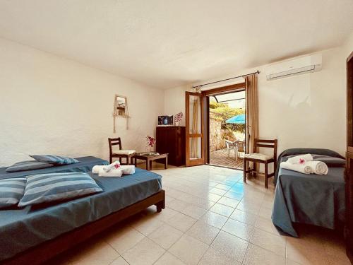 1 dormitorio con 2 camas y patio en Casette Belvedere, en Baja Sardinia