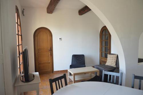 un salon avec une télévision, une table et des chaises dans l'établissement Maison avec jardin à proximité des plages, à Sète