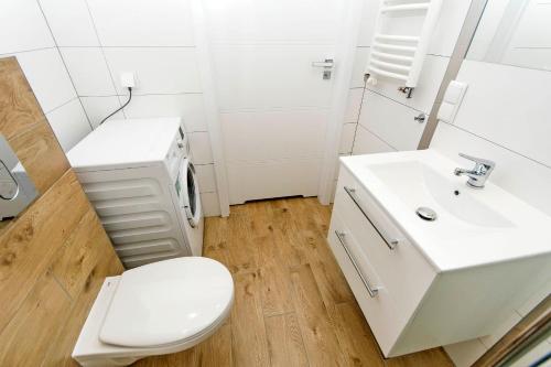 uma casa de banho branca com um WC e um lavatório em Apartament Baltic Sea 3 - Gdańsk Przymorze em Gdansk