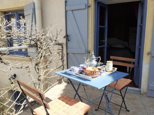 a blue table with a bowl of food on it at Les volets bleus in Charlieu