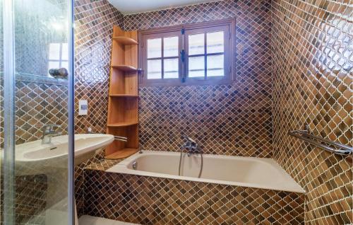 een badkamer met een bad, een wastafel en een raam bij Domaine De La Bastide Dagay in Anthéor