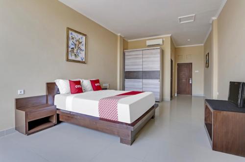 a bedroom with a large bed and a television at Moreno Homestay in Legian