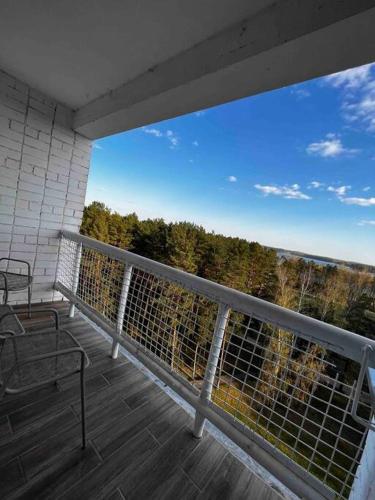 ヴィサギナスにあるStudio Apartment with Lake Viewの木々の景色を望むバルコニー(ベンチ付)