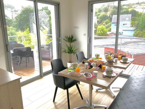 - une table avec de la nourriture dans une chambre avec balcon dans l'établissement Maison Holen, à Plougonvelin