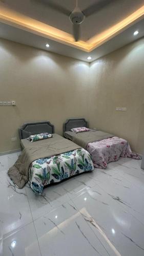 two beds sitting next to each other in a room at استراحة المرجانalmarjan chalet in Ḑibāb