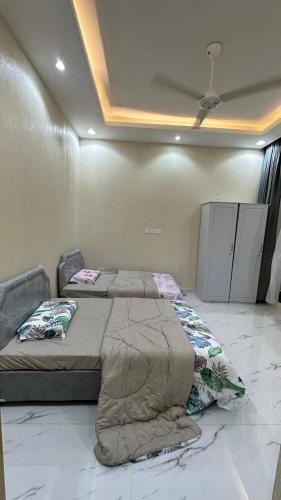 a bedroom with two beds and a ceiling at استراحة المرجانalmarjan chalet in Ḑibāb