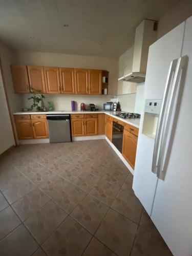 une cuisine avec des armoires en bois et un réfrigérateur blanc dans l'établissement Maison luxe entier a Limay, à Limay