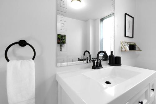 a white bathroom with a sink and a mirror at Urban Loft 2-story 1BR Near DT on Historic Street in Columbus