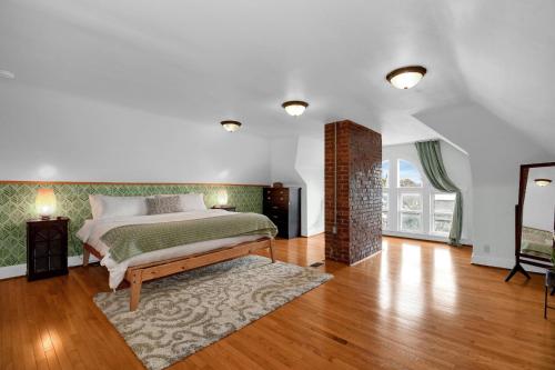 a bedroom with a bed and a rug on a wooden floor at Urban Loft 2-story 1BR Near DT on Historic Street in Columbus
