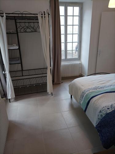 une chambre avec un lit et une grande fenêtre dans l'établissement O'Couvent - Appartement 44 m2 - 1 chambre - rdc ext, à Salins-les-Bains