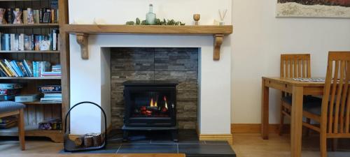 a living room with a fireplace and a desk at Bovinda Cottage - By the Beach, Bettystown in Bettystown
