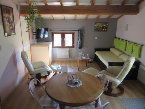 sala de estar con mesa, sillas y sofá en Gîte La Bodib, en Fabras