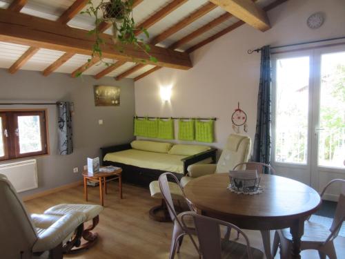 ein Wohnzimmer mit einem Bett und einem Tisch in der Unterkunft Gîte La Bodib in Fabras