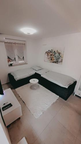 a white room with two beds and a table at Near beach studio in Kaštela