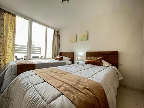 een slaapkamer met 2 bedden en een groot raam bij Asiminas lovely house in Ixia