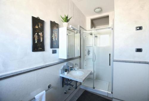 a white bathroom with a sink and a shower at Al Massimo Piacere in Palermo