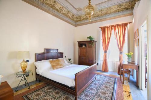 a bedroom with a bed and a chandelier at Al Massimo Piacere in Palermo
