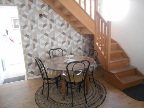 une salle à manger avec une table et des chaises et un escalier dans l'établissement maison bleue, à Vichy