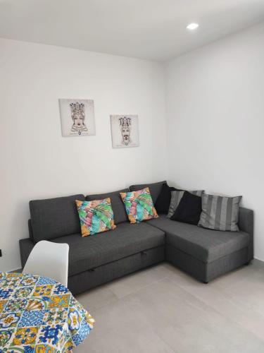 a couch in a living room with two pillows at I Mori di Brucoli in Brucoli