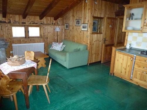 a living room with a green couch and a table at Il Refuge CIR 119 in Courmayeur