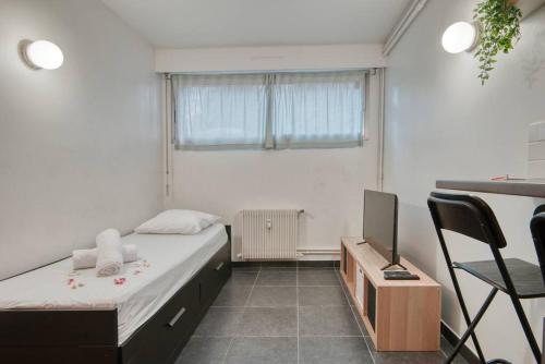 sypialnia z łóżkiem, biurkiem i telewizorem w obiekcie MILANO - Studio à deux pas de l’Avenue du Prado w Marsylii