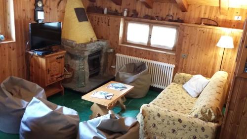 a living room with a couch and a tv and a table at Il Refuge CIR 119 in Courmayeur