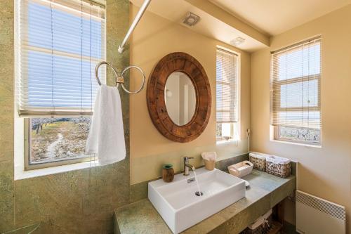 W łazience znajduje się umywalka i lustro. w obiekcie Estate Prophet Elias w mieście Egina