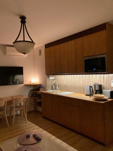 a kitchen with wooden cabinets and a dining table at Apartament Comfort Kahlberg in Krynica Morska