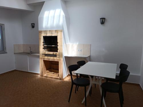 a dining room with a table and a fireplace at Casa Zeferino in Ferragudo