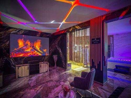a room with a tv with a fire on the screen at Krystalisya Room Suite Spa Privatif Sauna Jacuzzi Siege Massant in Marseille