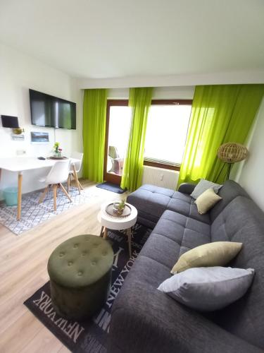 un soggiorno con divano e tavolo di Erholungs- Apartment am Kurpark & Thermen Bad Urach a Bad Urach