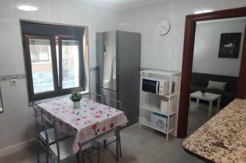 a small kitchen with a table and a refrigerator at apartamento a 19min de Gijón y 15 de Oviedo in Langreo